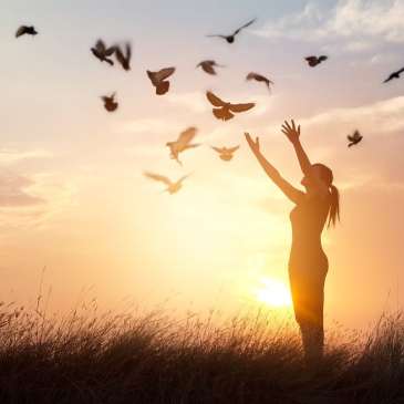 woman releasing doves into the air, liberating them