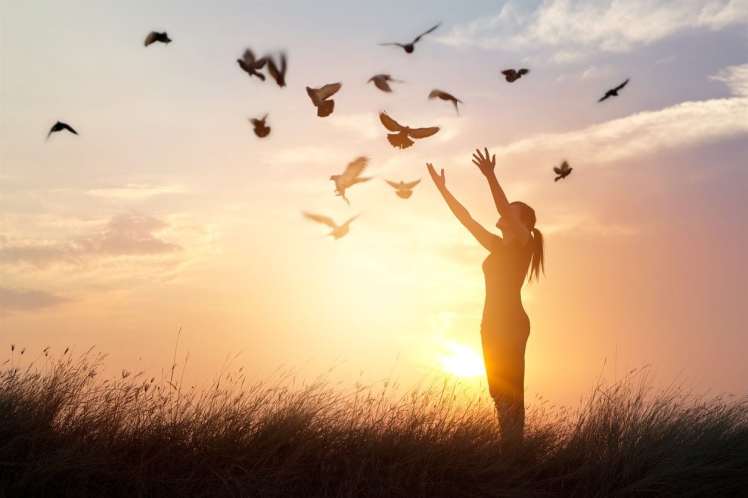 woman releasing doves into the air, liberating them