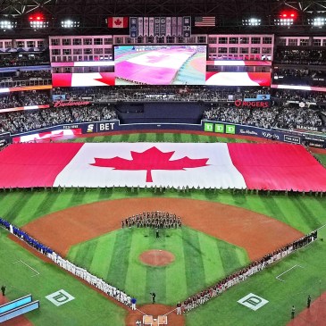 An aerial shot of the rogers centre baseball field with a Canadian flag prominently visible on the ground.